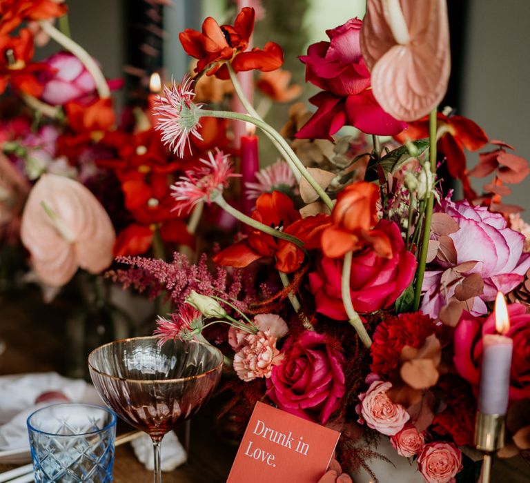 Red and Pink Floral Centrepieces with Coloured Taper Candles and Modern Wedding Stationery Design