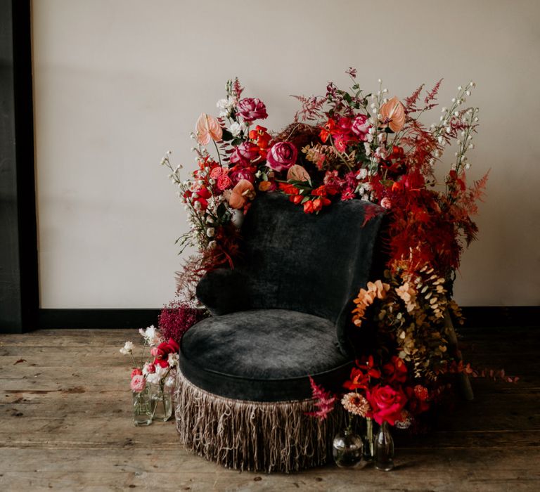 Velvet Chair Covered in Red and Pink Wedding Flowers