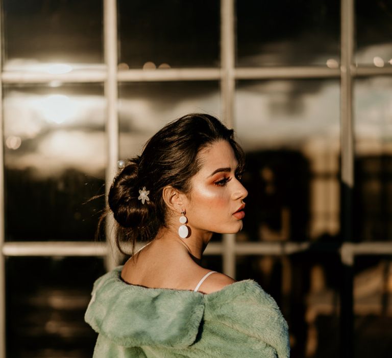 Bride with Messy Bun Updo, Disc Earrings and Blue Teddy Coat