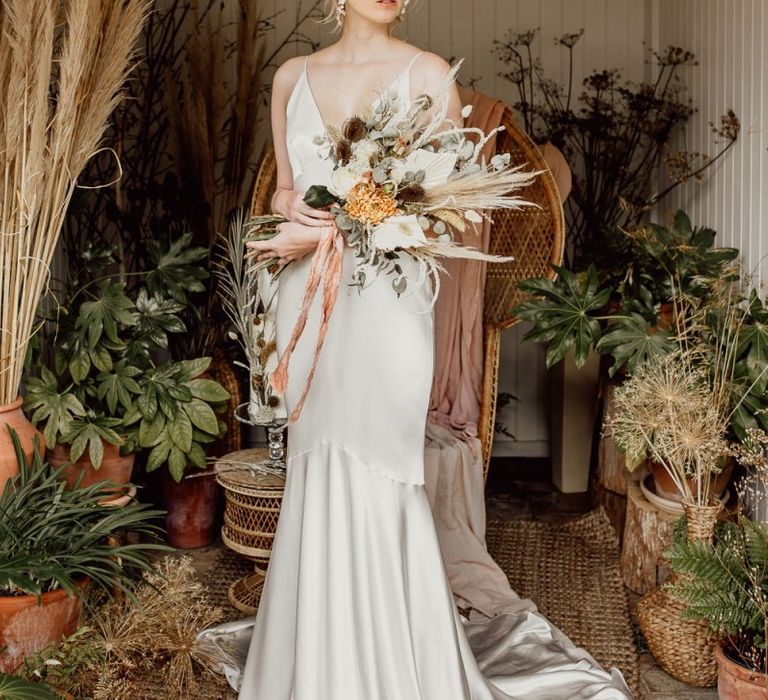 Bride in Minimalist Wedding Dress Holding a Dried Flower Wedding Bouquet Tied with Ribbon