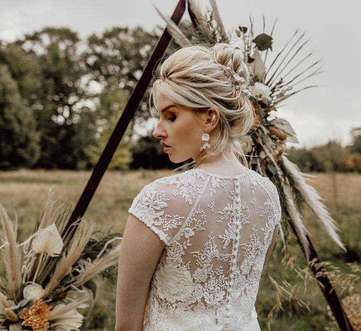 Bride in Delicate Lace Bridal Top with Buttons Down the Back and Matching Earrings and Hair Accessories