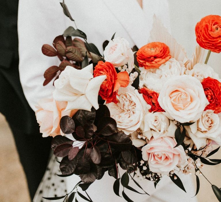 Pink and red wedding flowers with roses and ranunculus