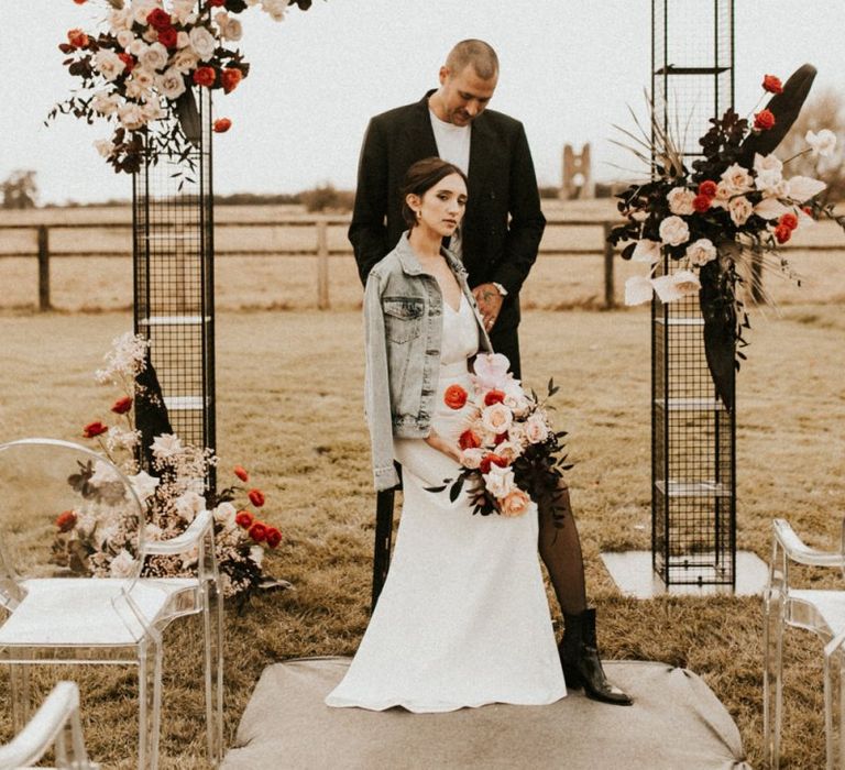 Metal altar frame with pink and red wedding floral decor