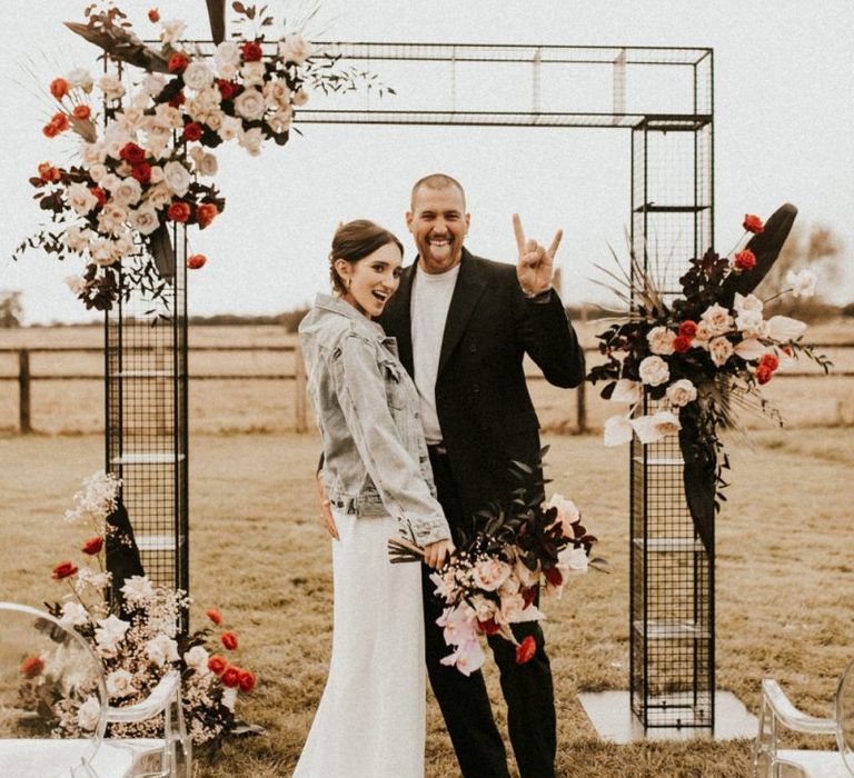 Stylish bride and groom at contemporary metal altar at Godwick Great Barn