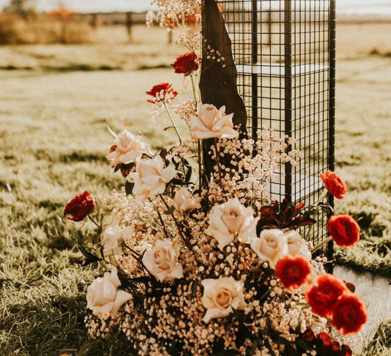 Pink and red wedding ceremony floral arrangement