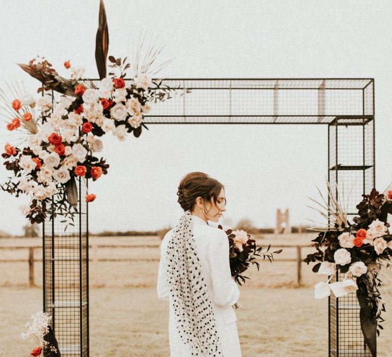 Stylish bride in white blazer and black polka dot veil at Godwick Great Barn