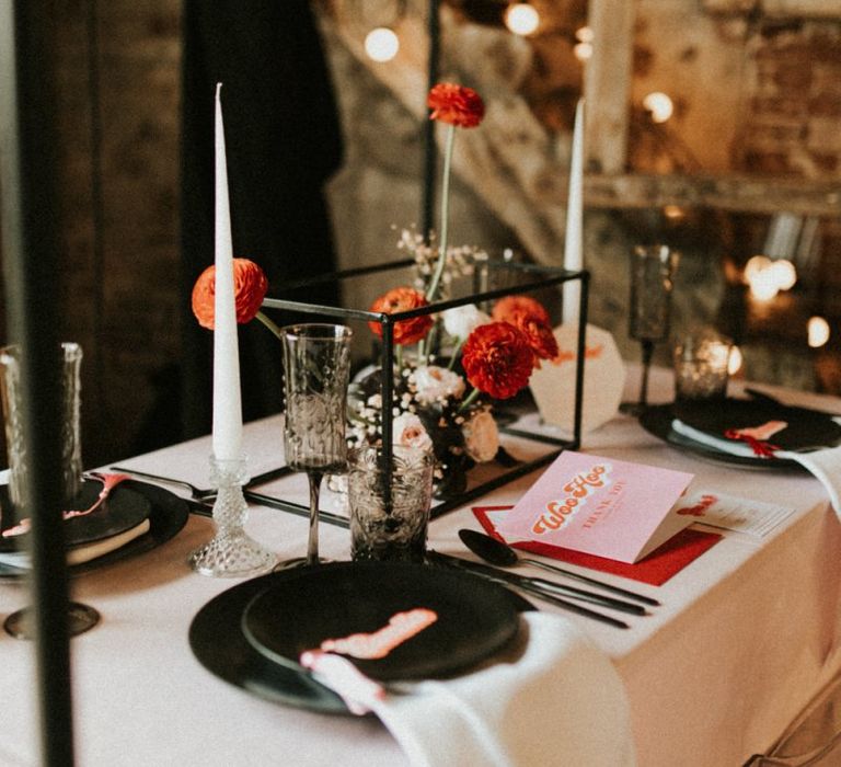 Black tableware and pink and red retro wedding stationery