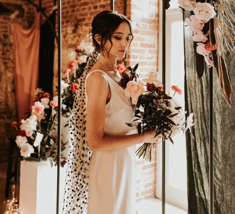 Stylist bride in minimalist wedding dress and black polka dot wedding veil