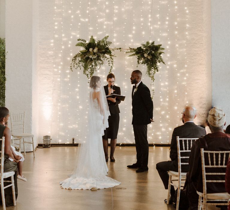 The Ceremony. Bride wears dress by Pronovias. Groom wears green velvet blazer from Gieves &amp; Hawkes in this Green And White Luxe, City Wedding. Photography by The Curries.