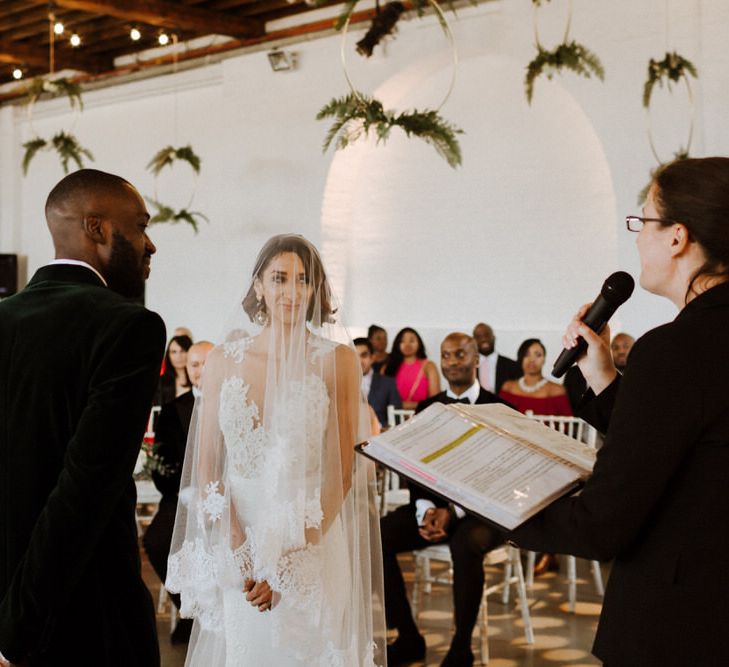 The Ceremony. Bride wears dress by Pronovias. Groom wears green velvet blazer from Gieves &amp; Hawkes in this Green And White Luxe, City Wedding. Photography by The Curries.