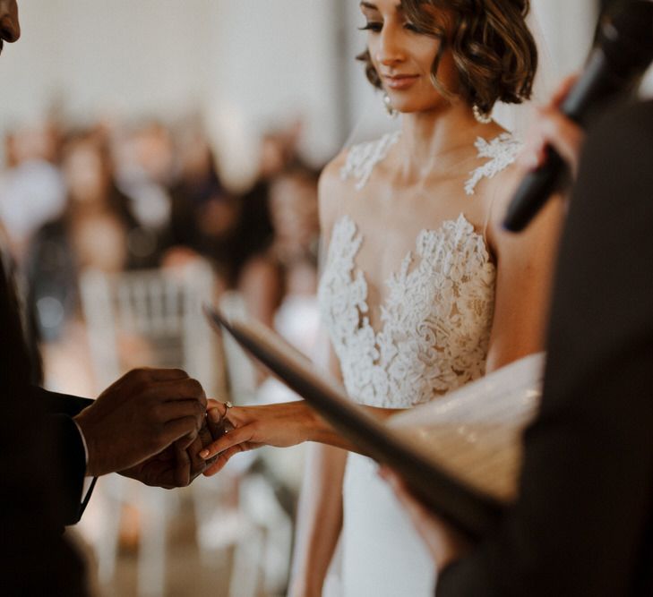 The Ceremony. Bride wears dress by Pronovias. Groom wears green velvet blazer from Gieves &amp; Hawkes in this Green And White Luxe, City Wedding. Photography by The Curries.