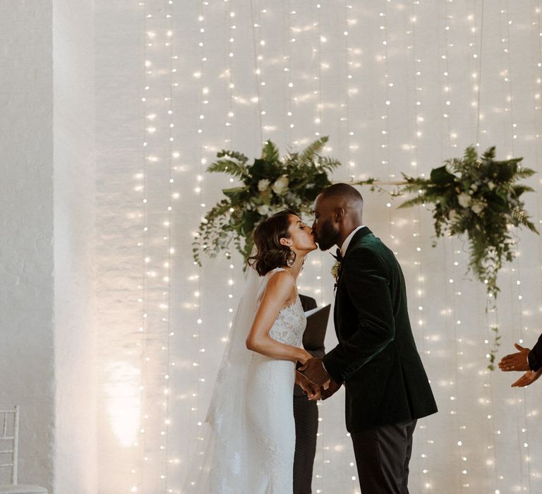 The Ceremony. Bride wears dress by Pronovias. Groom wears green velvet blazer from Gieves &amp; Hawkes in this Green And White Luxe, City Wedding. Photography by The Curries.