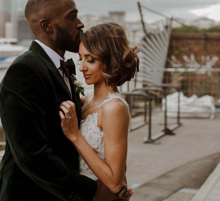 Bride wears dress by Pronovias. Groom wears green velvet blazer from Gieves &amp; Hawkes in this Green And White Luxe, City Wedding. Photography by The Curries.