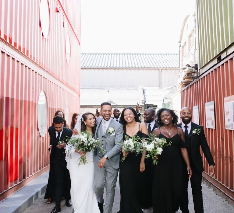 Monochrome Bridal Party Fashion. Bridesmaids in Black Boohoo Dresses. Bride in Wed2b. Groom in Grey Moss Bros. Groomsmen in Their Own Black Suits. Modern Warehouse Wedding in London at Trinity Buoy Wharf. Images by Captured by Katrina Photography