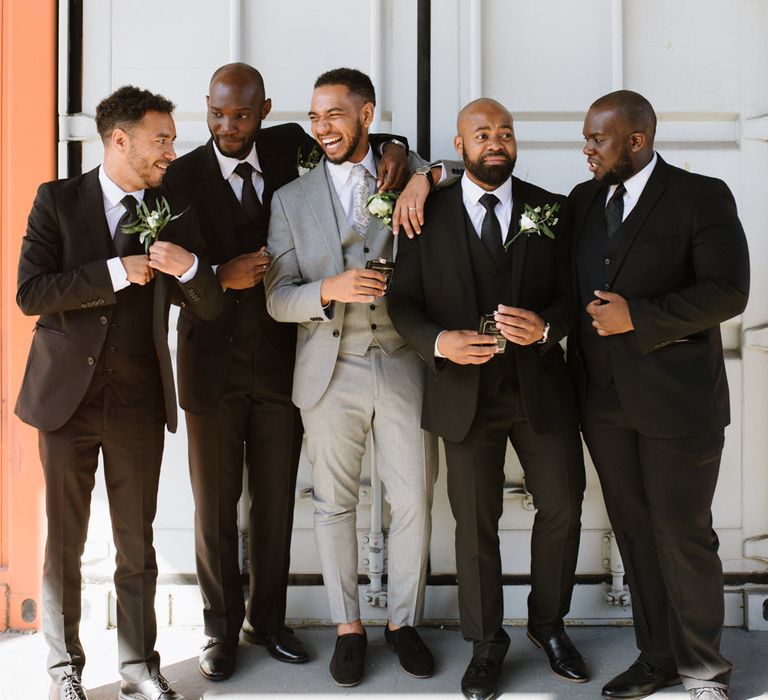 Monochrome Bridal Party Fashion. Groom in Grey Moss Bros. Groomsmen in Their Own Black Suits. Modern Warehouse Wedding in London at Trinity Buoy Wharf. Images by Captured by Katrina Photography