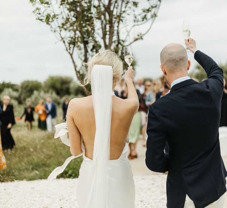 Bride and groom toast guests at Masseria Moroseta