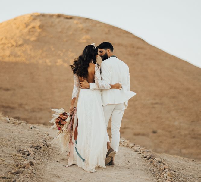 Boho bride and groom arm in arm at Moroccan wedding