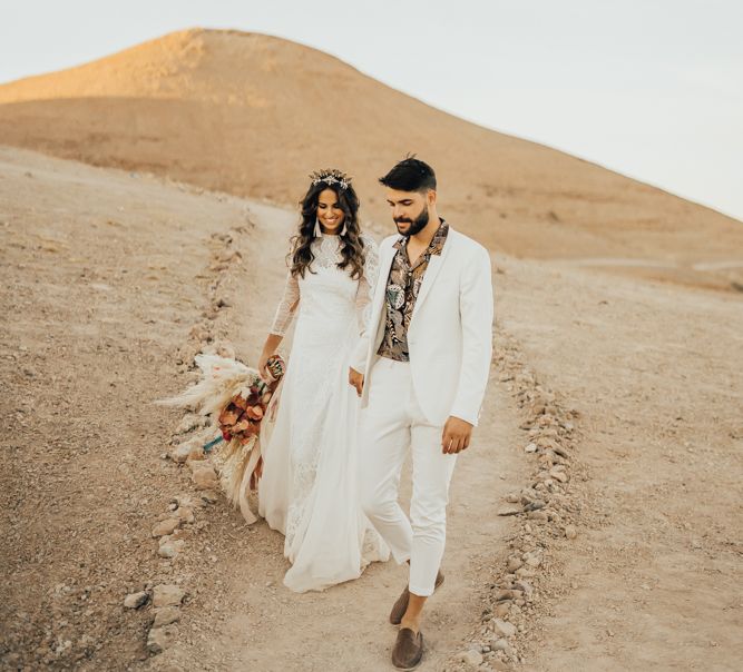 Stylish bride and groom holding hands at Moroccan wedding