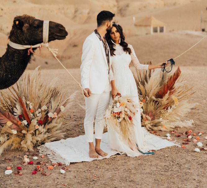 Bride and groom portrait with camels at Marrakesh desert elopement