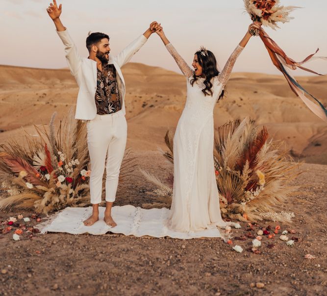 Stylish bride and groom at Moroccan wedding  in the dessert