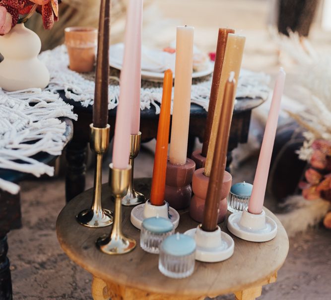 Coloured taper candles in rust, blush and neutral tones