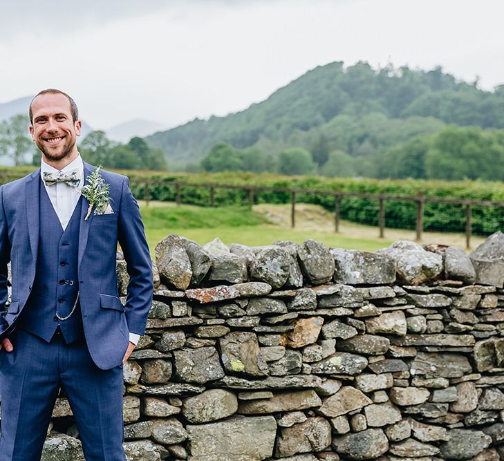 Groom In Blue Suit With Floral Bow Tie From Moss Bros. // Image By Sarah Beth Photo