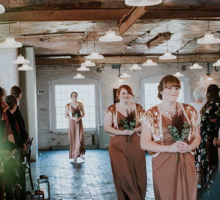 Wedding Ceremony Bridesmaid Entrance in Bronze ASOS Dresses | Copper &amp; Greenery Industrial Winter Wedding at The West Mill Derby, Styled by The Vintage House That Could | Rosie Kelly Photography | Jason Lynch Weddings