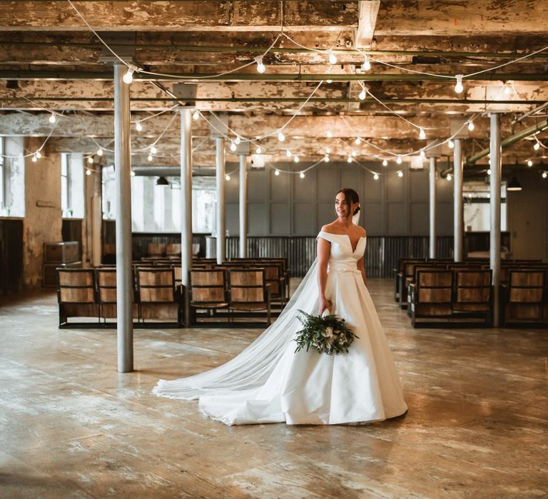 Industrial wedding with bride in off the shoulder wedding dress and cupcake wedding cake