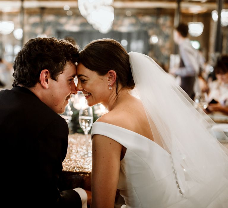 Bride and groom steal a moment during wedding breakfast