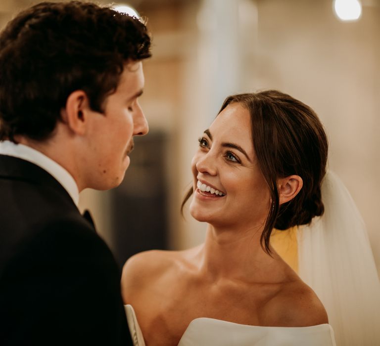 Bride in off the shoulder wedding dress with drop earrings and veil