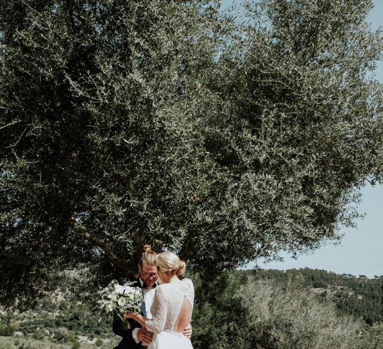 Bride and Groom Sharing their First Look with Bride in a Lace Back Rembo Styling Wedding Dress