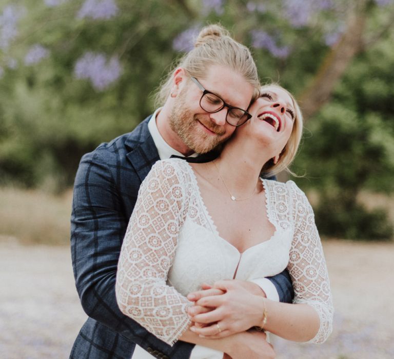 Bride in Rembo Styling Wedding Dress and Groom in Checked Blazer Embracing