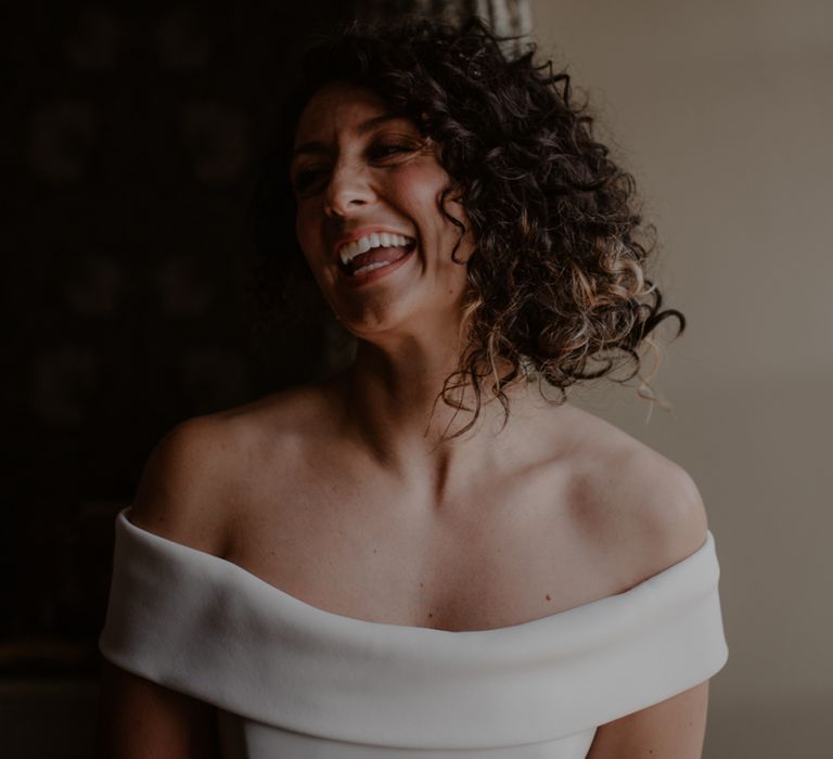 Bride with curly hair in off the shoulder wedding dress