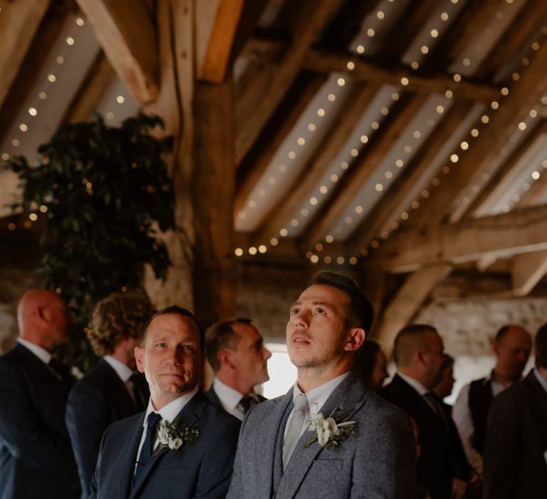 Groom in blue wool suit waiting at the altar