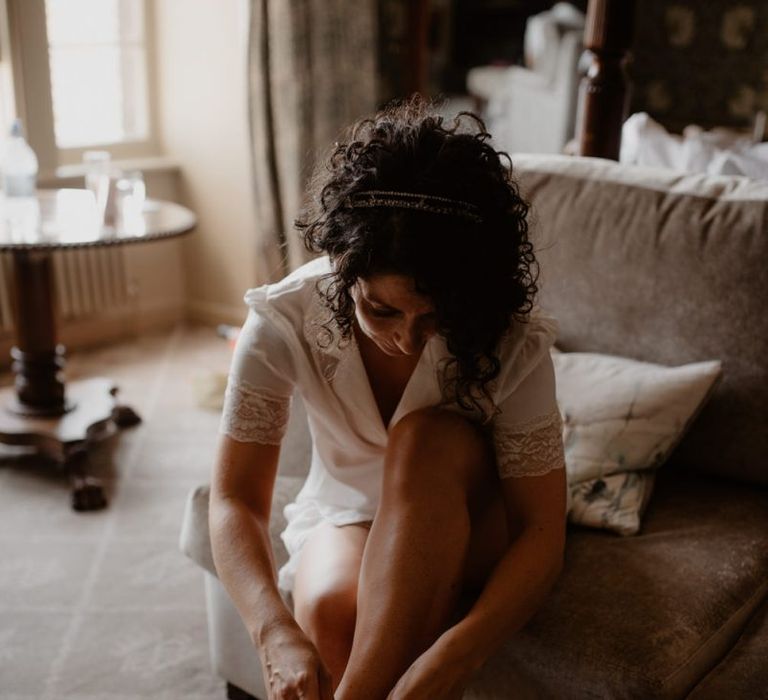 Bride putting on her wedding shoes