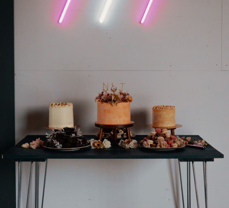 Neon wedding signs above cake table