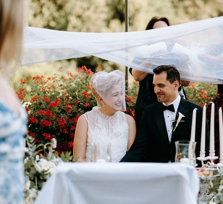 Bride in 3D flower wedding dress with groom during Persian wedding ceremony