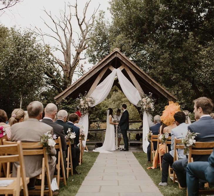 Outdoor Wedding Ceremony With Bride and Groom and Altar Decor