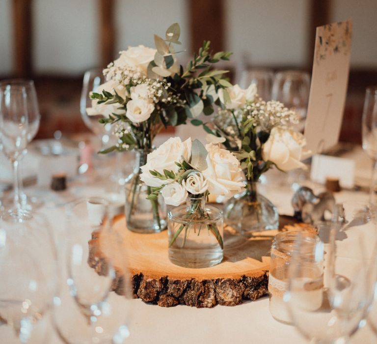 White wedding flower decor and rustic tree slice for Micklefield Hall wedding