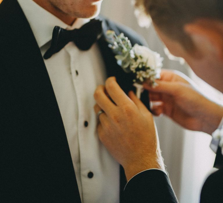 Groom in black tuxedo with white floral buttonhole