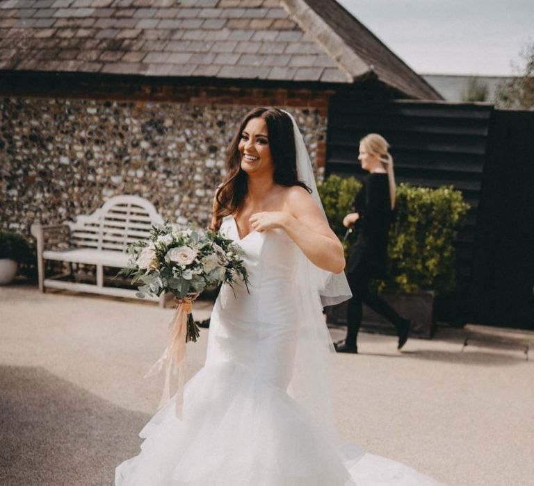 Strapless fishtail wedding dress with blush bouquet