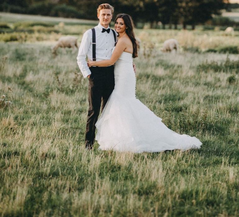 Bride in strapless fishtail wedding dress with groom in tuxedo