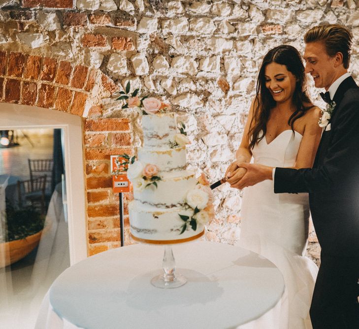 Bride and groom cut wedding cake