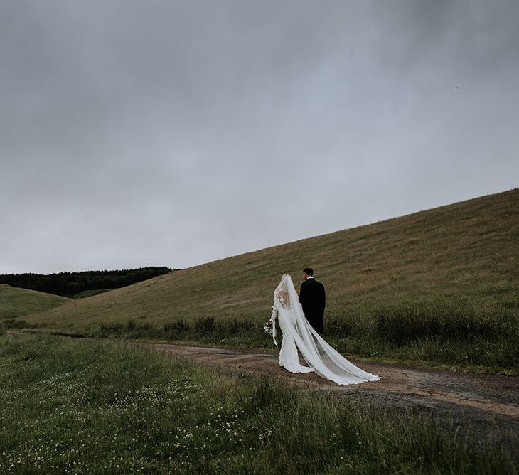 Bride and Groom In Countryside with Veil