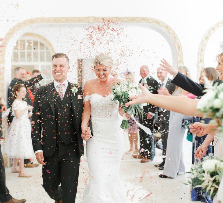 Confetti Moment with Bride in Lace St Patrick Wedding Dress and Groom in Grey Empire Outlet Suit