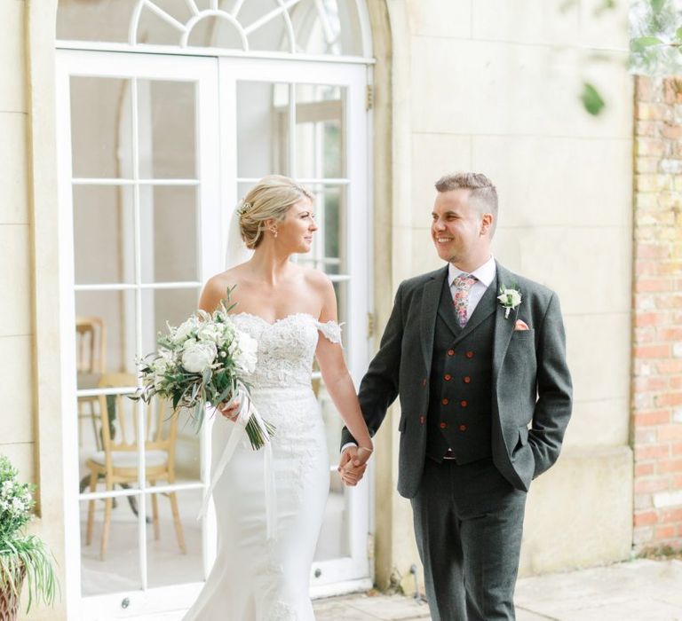 Bride and Groom Holding Hands in Front of the Orangery at Northbrook Park