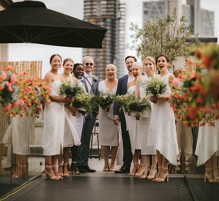 Bridal Party First Look | Bridesmaids in Mismatched White Dresses | Bridesmen in Blue Suits | Homemade Bouquets of White Flowers, Ferns and Foliage | Bike Shed Motorcycle Club Wedding for ELLE Digital Editor | Nigel John Photography