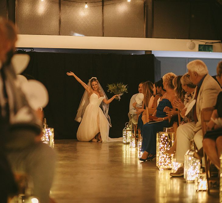 Entrance of the Bride | Bespoke Wedding Gown with Blush Underskirt and One Off Shoulder Strap | Fingertip Length Veil Customised with Feathers | Half Up Half Down Bridal Hair | Nude Topshop Shoes with Pom Pom | Homemade Bouquet of White Flowers, Ferns and Foliage | Lanterns Filled with Fairylights | Bike Shed Motorcycle Club Wedding for ELLE Digital Editor | Nigel John Photography