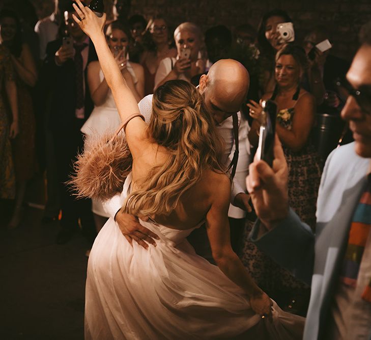 First Dance | Bride in Bespoke Wedding Gown with Blush Underskirt and One Off Shoulder Strap | Half Up Half Down Bridal Hair | Groom in Grey Puppy Tooth Check Two-Piece Paul Smith Suit with Amber Tie Pin, Pocket Square and Braces | Bike Shed Motorcycle Club Wedding for ELLE Digital Editor | Nigel John Photography