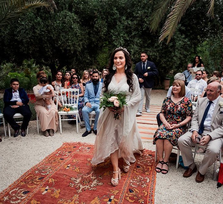 Outdoor Wedding Ceremony | Moroccan Rugs Aisle Wedding Decor | Bride in Rue de Seine Bridal Gown | Paradise Destination Wedding at Jnane Tamsna in Marrakech, Morocco | Nordica Photography | Matteo Castelluccia Film